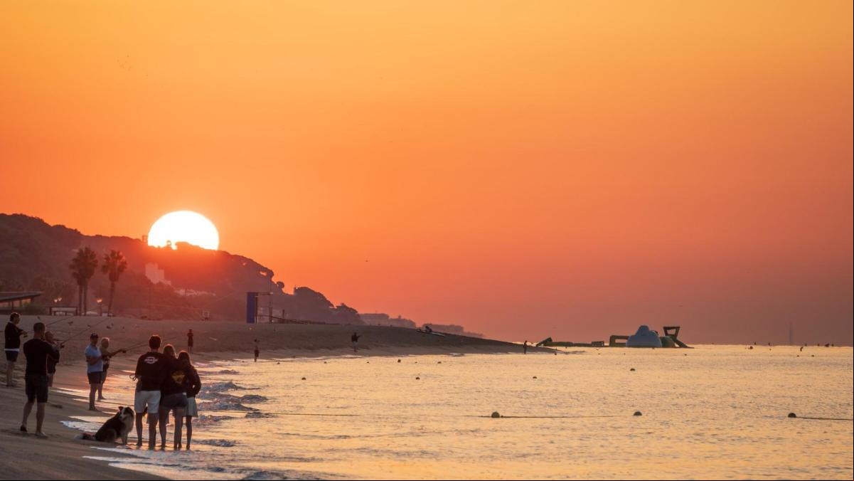 Expectación por ver el sol en la playa del Cavaió