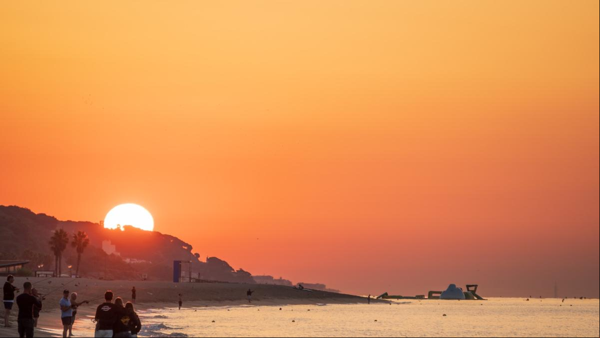 Expectación por ver la salida del sol en la playa del Cavaió