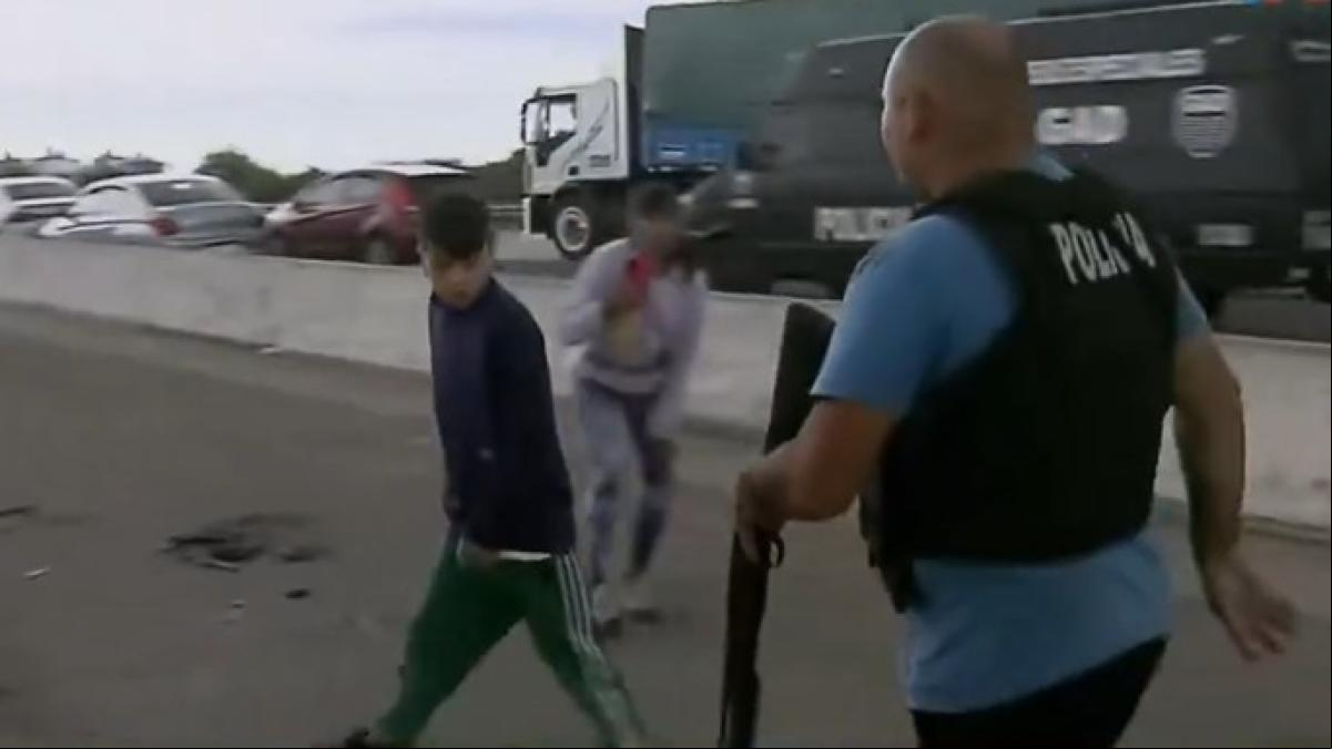 Un niño amenaza con un arma blanca a un policía en medio de una protesta de vecinos